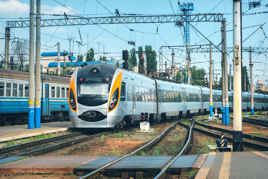Se muestra un tren de alta velocidad llegando a una plataforma férrea